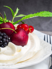 meringues pavlova cake with fresh cherry, blackberry, strawberry on concrete background
