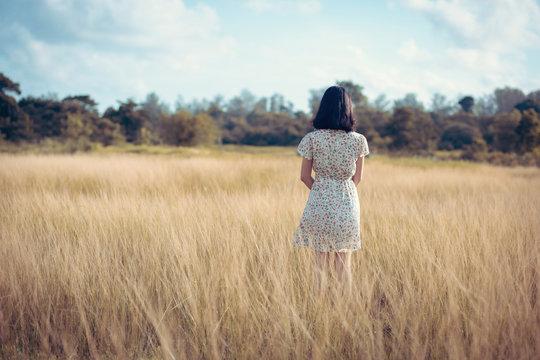 young woman in a wide open field with pleasure Vintage style tone