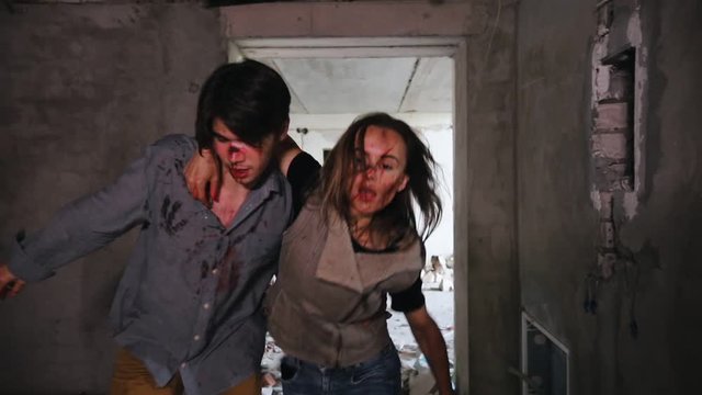 A zombie attack in abandoned building. Tired survivors escaping from the zombies