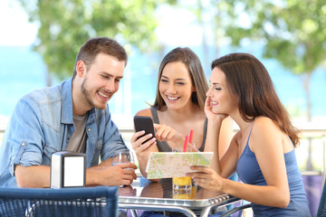 Group of tourists checking phone and map on vacation