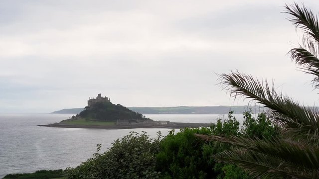 View from a terrace in Marazion of the english medieval castle and church of St Michael's Mount in Cornwall on a cloudy spring day. 4k footage