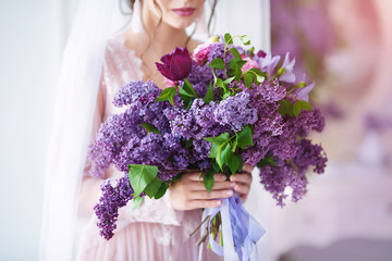 Beauty portrait. Beautiful woman with sensual lips holding violet flowers.