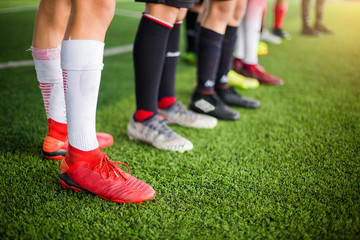 Fototapeta premium boy soccer players are put multi color sport shoes and standing on green artificial turf with coach