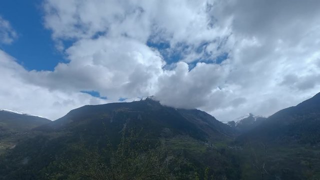 Time-lapse of mountains in the French Alps with blue sky and cloud movement.