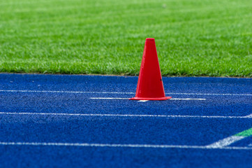 traffic cone on blue tartan track in stadium 