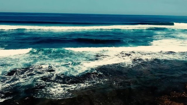 Aerial footage filmed with a drone overlooking the beach and sea of crashing waves with a deep blue ocean on the Bluff in Africa southern hemisphere.