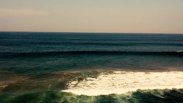 Aerial footage filmed with a drone overlooking the beach and sea of crashing waves with a deep blue ocean on the Bluff in Africa southern hemisphere.