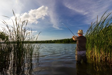 angler catching the fish during summer day
