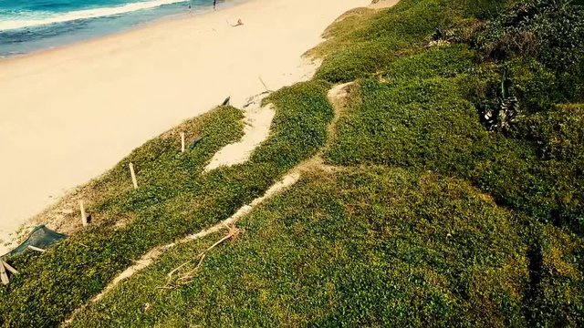 Aerial footage filmed with a drone overlooking the beach and sea of crashing waves with a deep blue ocean on the Bluff in Africa southern hemisphere.