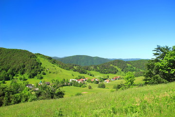 Fototapeta na wymiar Mountain village in green landscape, panoramic view. Begovo razdolje in Croatia.