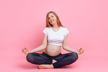 Young beautiful pregnant woman does yoga exercise