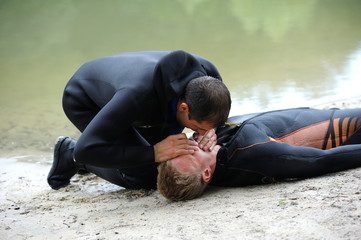 Lesson of artificial respiration. Lifeguard giving drowning mouth-to-mouth resuscitation