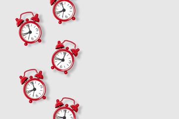 Work concept. Flat lay scattered red alarm clocks on a gray background with space for text. Flat lay. Work concept.