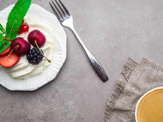 Meringue dessert Pavlova cake and cup of coffee. Stone background, close-up