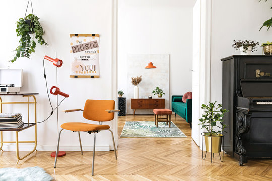 Stylish compositon of retro home interior with mock up poster frame, vintage orange chair, piano,furnitures, design lamps, gold shelf, plants and elegant accessories. Nice home decor of living rooms. 