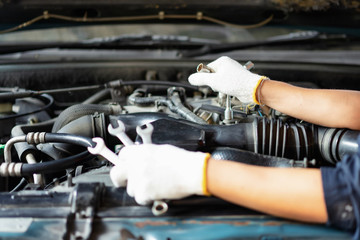 Fototapeta na wymiar Car mechanic holding a wrench in his hand.Close up of hands mechanic doing car service and maintenance.Engine Maintenance concept.Auto car repair service