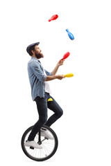 Male juggler on a unicycle juggling with clubs - obrazy, fototapety, plakaty