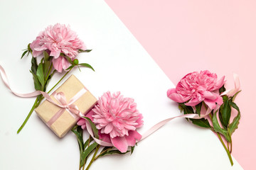 A bunch of peonies scattered around randomly with surprise gift boxes in boxes on a white background