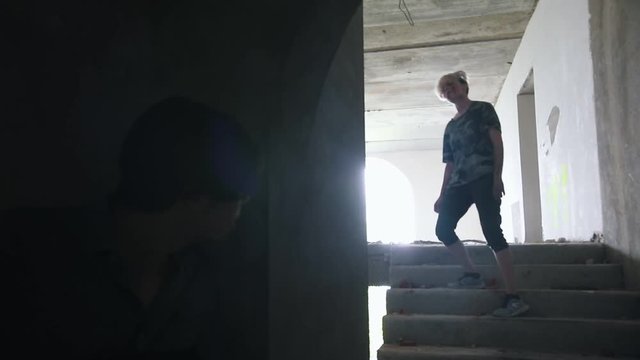 A zombie walking on the stairs and a man survivor aiming with a gun in them