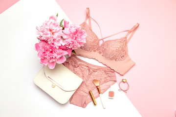 Womens beautiful lacy underwear with accessories, a bouquet of flowers peonies, handbags on a pink...