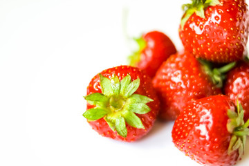 Red strawberries heap on white background view. Selective soft focus. Text copy space.