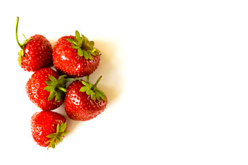 Red strawberries heap on white background view. Selective soft focus. Text copy space.