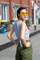 Asian Chinese model girl influencer street shot. Wearing Blue top and army green pants. Street Graffiti background.