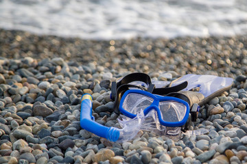 mask, snorkel and flippers lie on the beach
