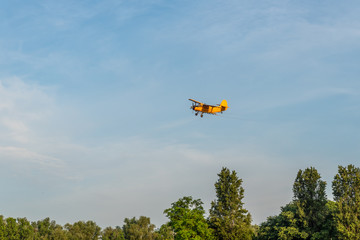 Airplane with twin wings and a propeller spraying mosquitoes above the city