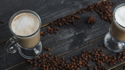 Cappuccino or mocha coffee on a dark wooden table with copyspace