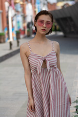 Asian Chinese model girl influencer street shot. Wearing pink dress and red shoes. Street Graffiti background.