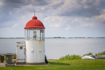 Fototapeta na wymiar Small lighthouse on the coast of Marken, Netherlands.