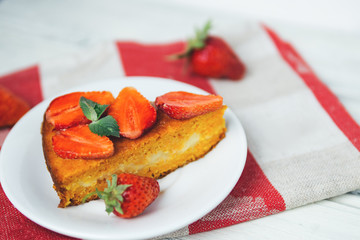 very tasty carrot cake decorated with strawberries on a white table
