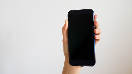 Isolated female hand holding a phone with black screen