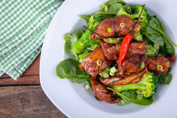 spicy chicken thigh dish over spinach bed
