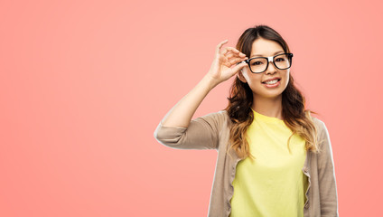 people, education and school concept - happy asian woman or student in glasses fixed by tape over living coral background