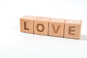 word LOVE on wood cube dices on white background.