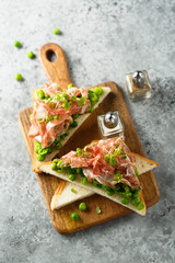 Healthy toasts with pea mash and prosciutto