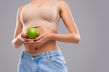 Crop slim lady with green apple