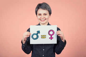 Pretty young woman hipster holding a white paper sheet with message for gender equality concept as...