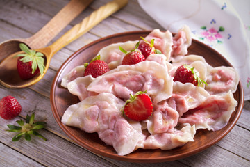 Dumplings, filled with strawberries. Varenyky, vareniki, pierogi, pyrohy. Diet vegetarian food
