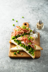 Healthy toasts with pea mash and prosciutto
