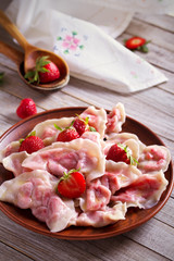 Dumplings, filled with strawberries. Varenyky, vareniki, pierogi, pyrohy. Diet vegetarian food