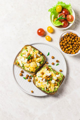 Breakfast toasts, soft scrambled eggs avocado goat cheese spicy chickpeas. Top view, space for text.
