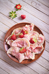 Dumplings, filled with strawberries. Varenyky, vareniki, pierogi, pyrohy. Diet vegetarian food