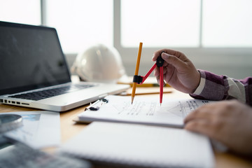 Architect working on blueprint with Circus.engineer inspective in workplace - architectural project, blueprints,ruler,calculator,laptop and divider compass. Construction concept. Engineering tools.