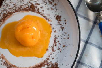 Scoop of passion fruit flavor ice cream with chocolate powder