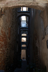 Fototapeta na wymiar Alley with stone arches. Albenga, Italy.