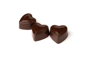 Three chocolate sweets in heart shape isolated on white background.	