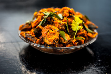 Famous Indian & Gujarati snack dish in a glass plate on wooden surface i.e. Patra or paatra consisting of mainly Colocasia esculenta or arbi ke pan or elephant ear leaves and spices.